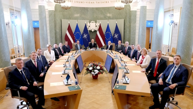 Ministru kabineta sēžu zālē pie galdiem sēž visi ministri