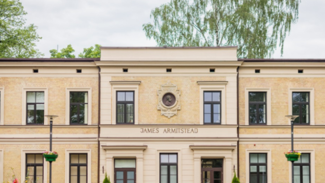 Bērnu slimnīcas ēka ar dekoratīvo apstādījumu priekšplānā