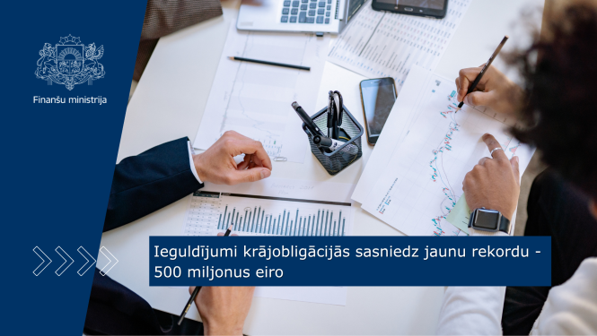 Uz galda stāv dokumenti ar dažādiem grafikiem un datiem, divi cilvēki tos pēta, veicot piezīmēs tajos