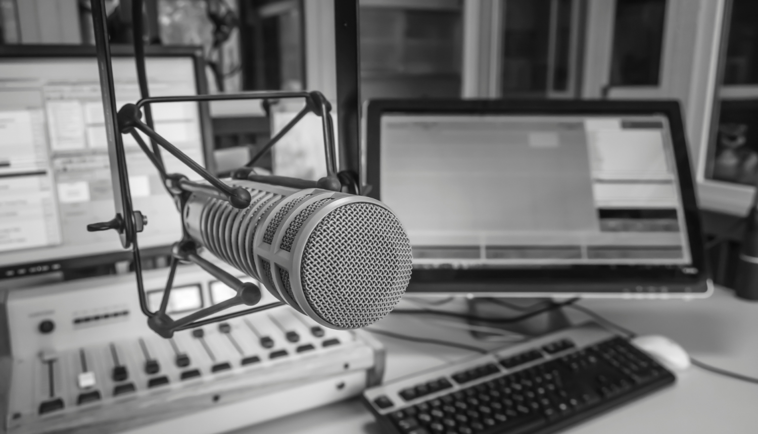 Melnbalts attēls, tuvplānā redzams mikrofons radio studijā