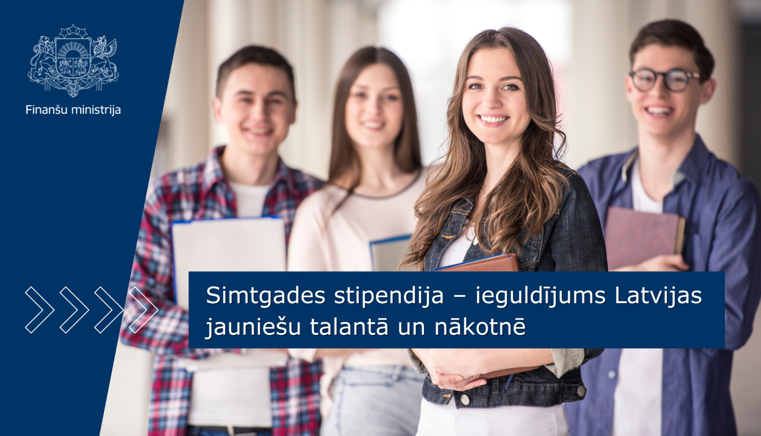 Stāv četri smaidīgi jaunieši, meitene nedaudz izvirzīta priekšplānā