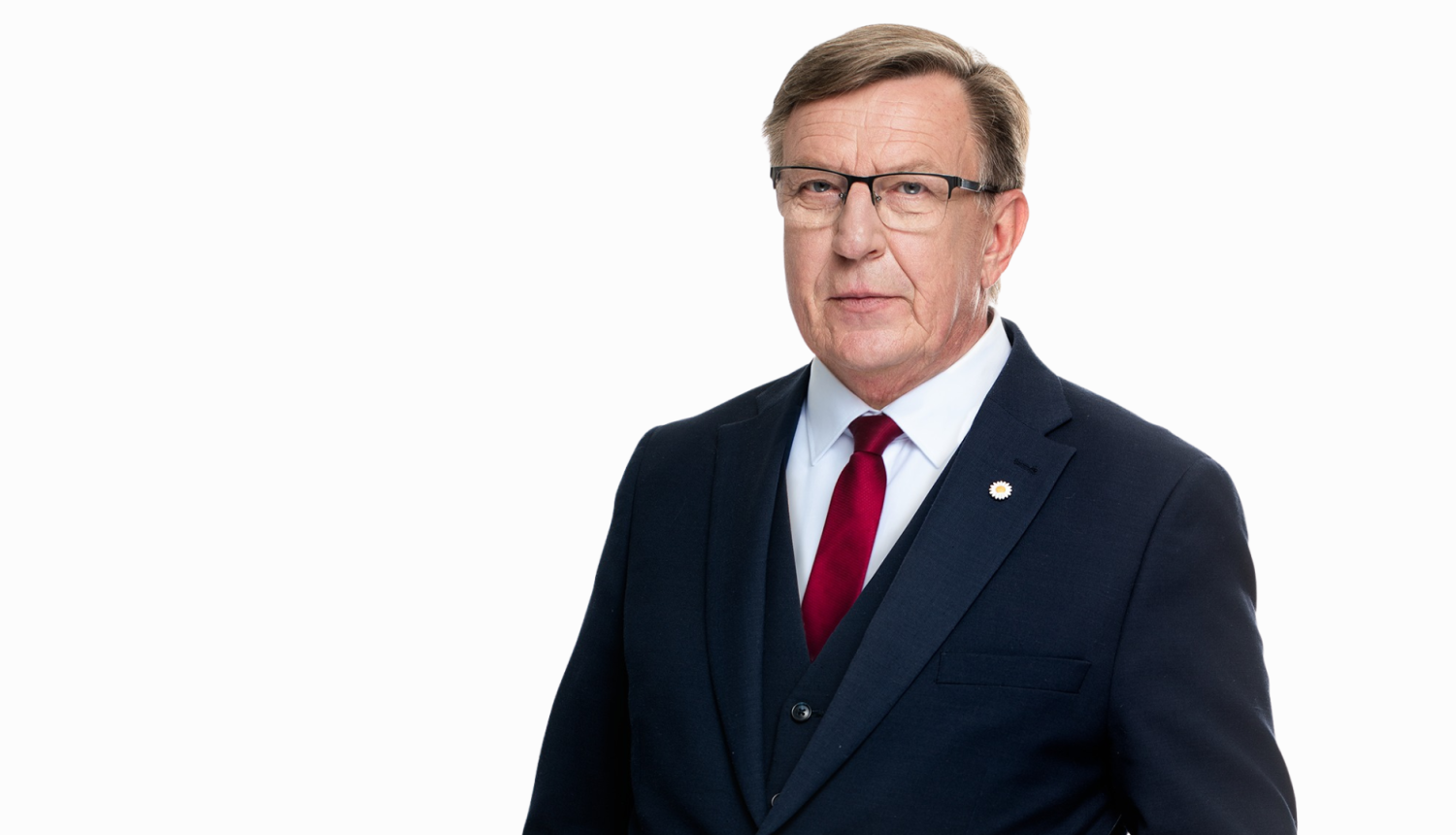 Portreta foto ar Māri Kučinski. Viņš ir ģērbies tumši zilā uzvalkā ar baltu kreklu un sarkanu kaklasaiti, ir brilles.