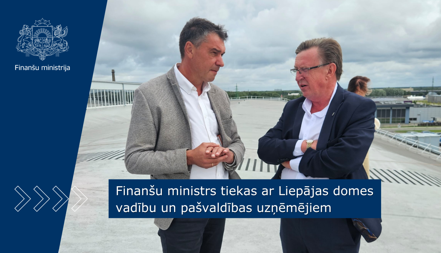 Finanšu ministrs sarunājas ar ar Liepājas domes priekšsēdētāju uz ēkas jumta terases.