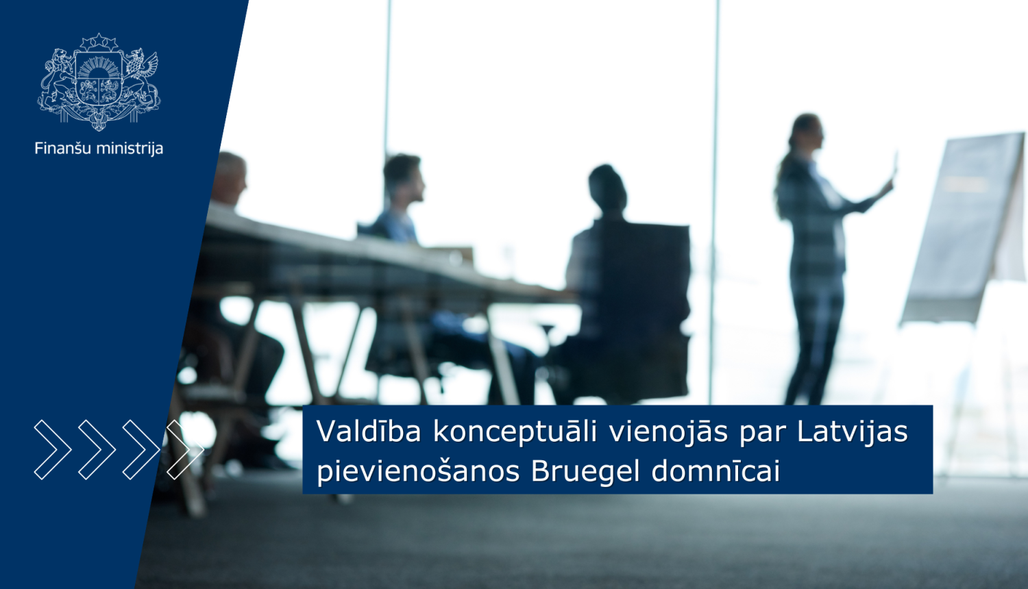 Konferenču zālēs ar panorāmas logiem redzami cilvēku silueti, kuri sēž pie galda un diskutē, viens cilvēks stāv pie pārvietojamas tāfeles un veic pierakstus