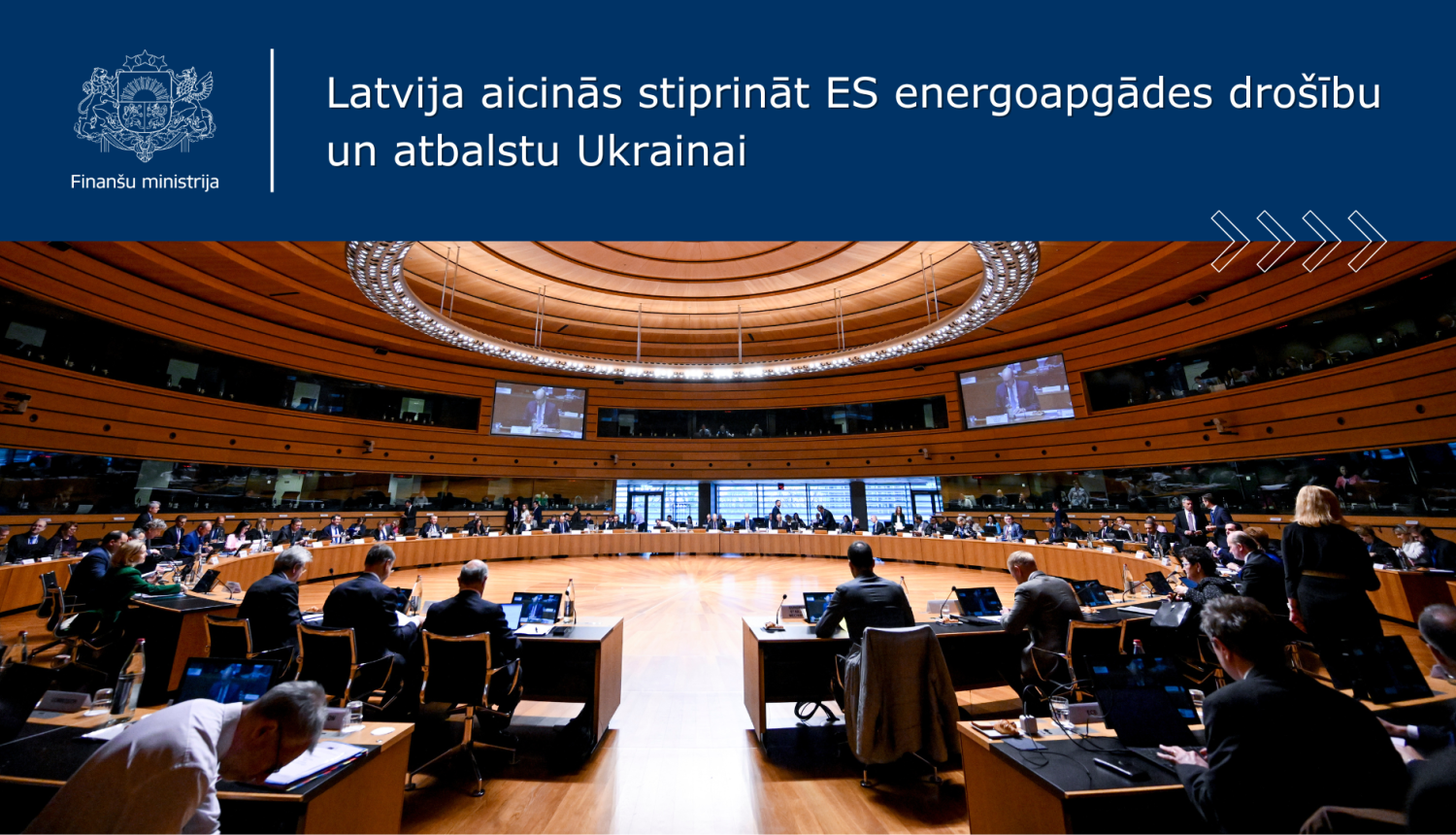 Apaļā konferenču zāle pie aplī izkārtota sēžu galda sēž sievietes un vīrieši lietišķā apģērbā, notiek sanāksme