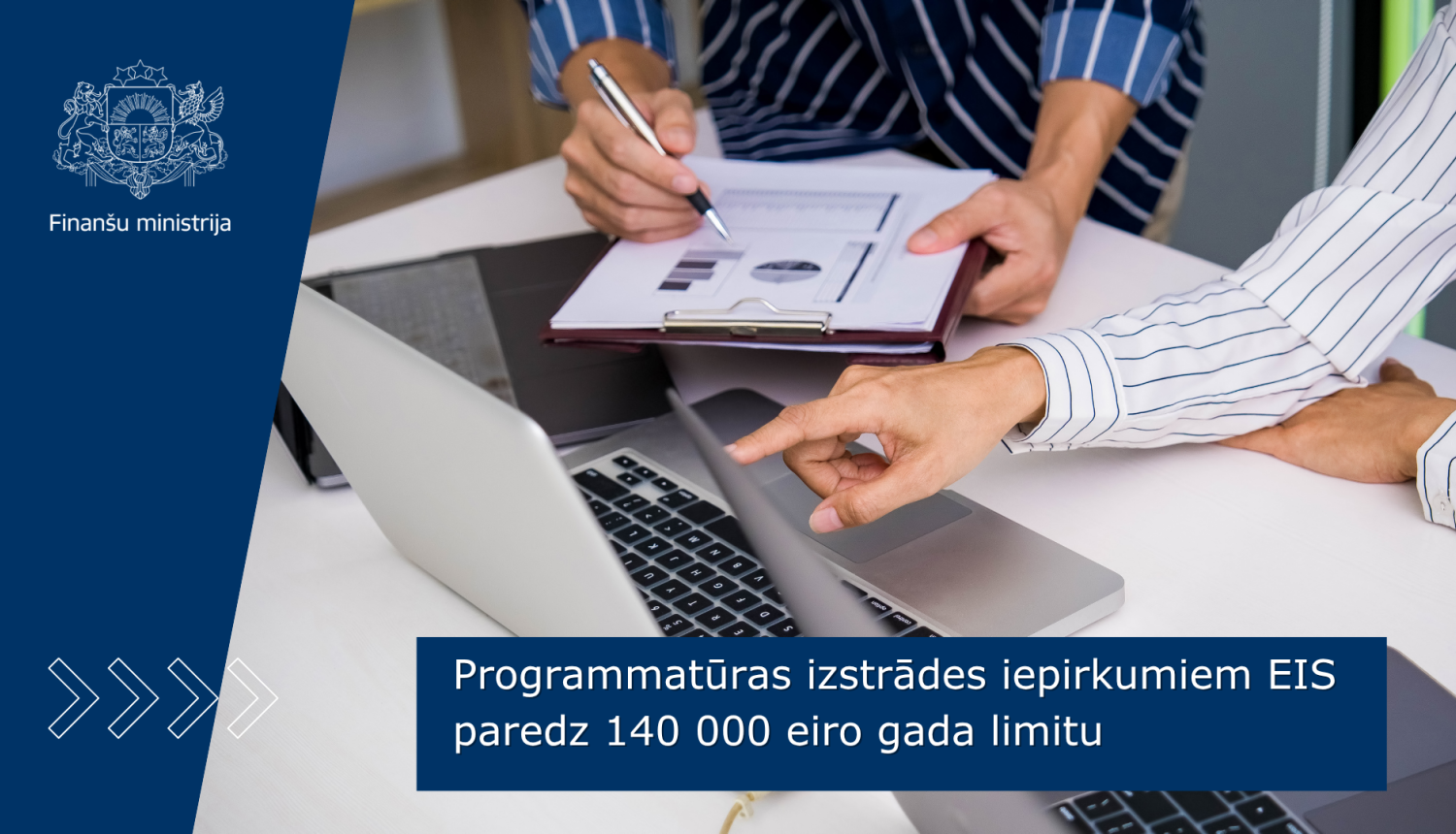 Divi cilvēki apspriež dokumentus pie klēpjdatora.