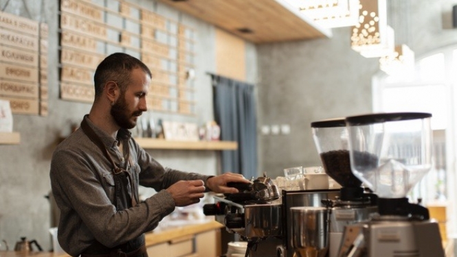 barista strādā nelielā kafejnīcā