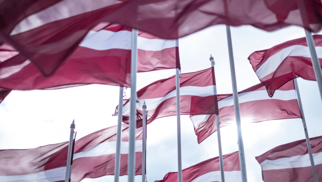 Attēlā redzami mastos plīvojoši Latvijas karogi