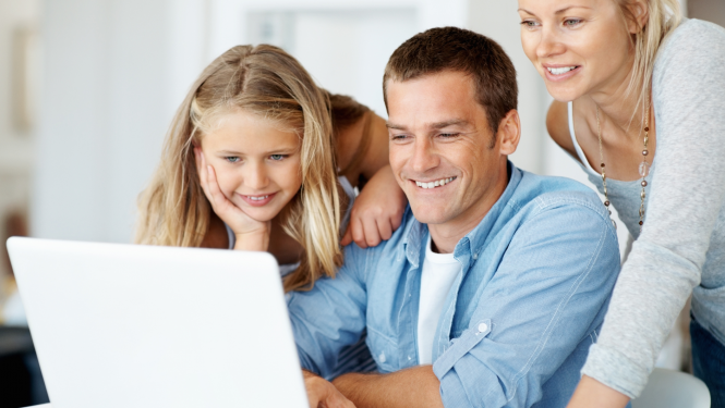Ģimene - meita, tētis un mamma skatās datora ekrānā un smaida