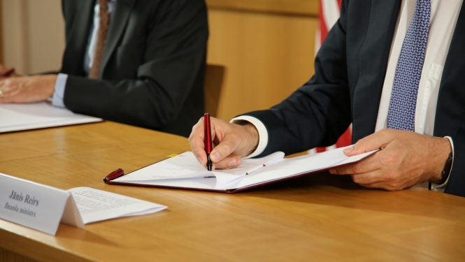 finanšu ministrs paraksta dokumentu