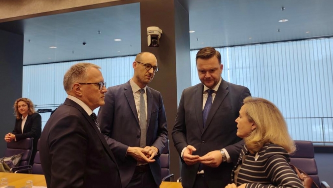 Četri cilvēki stāv viens pret otru un sarunājas