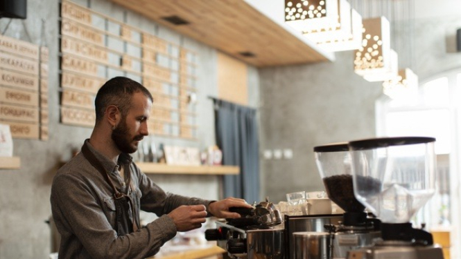 barista strādā nelielā kafejnīcā