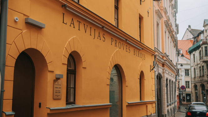 Trīsstāvu ēkas fasāde, uz kuras uzgleznots nosaukums Latvijas proves birojs