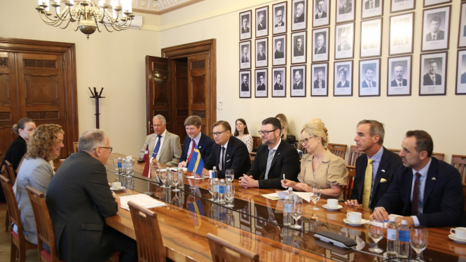 Abpus galdam sēž vīrieši un sievietes un diskutē