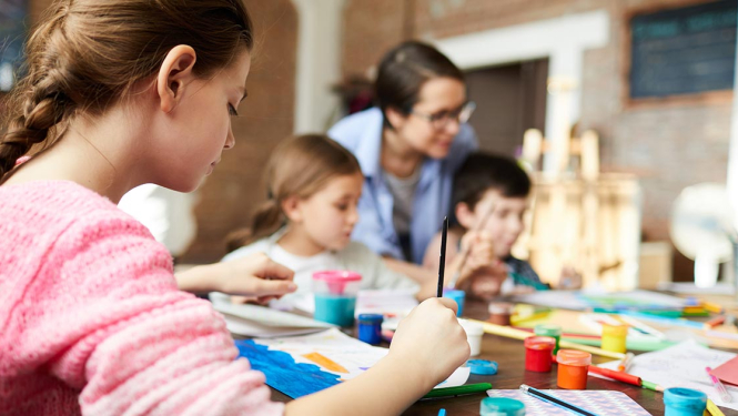 Bērni un pedagogs zīmēšanas nodarbībā