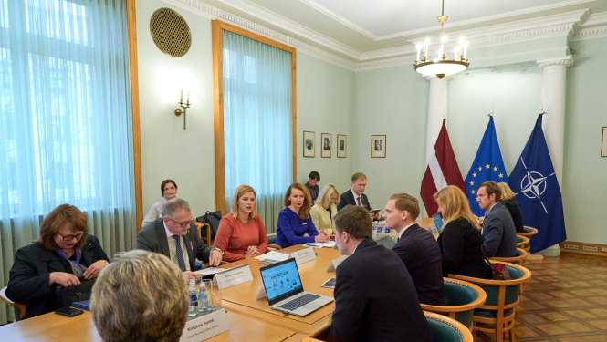 telpā abpus garam gldam sēž valsts amatpersonas un diskutē