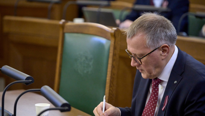 Finanšu ministrs Arvils Ašeradens sēž Saeimas tribīnēs