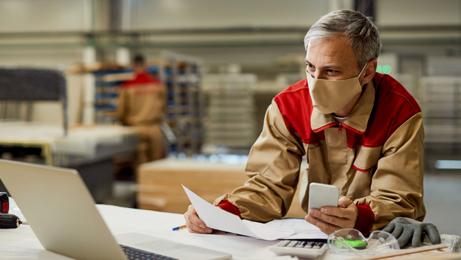 Vīrietis darba formā skatās datorā