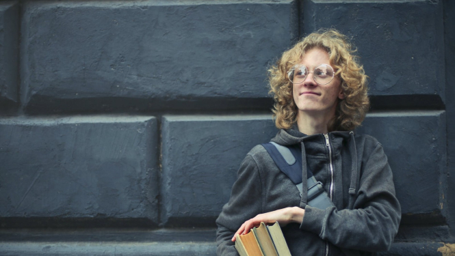 jauns puisis ar grāmatām rokās