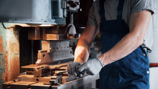 Darbinieks veic darbu pie iekārtas