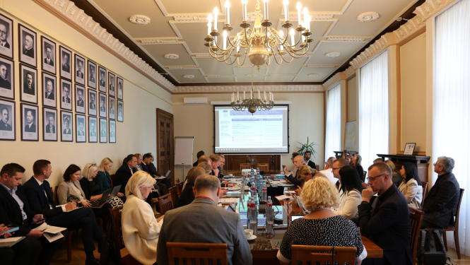 Cilvēki pie galda un ekrāns