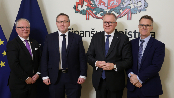 Attēlā redzami četri vīrieši tumšos uzvalkos un karogu un ģerboņa fona