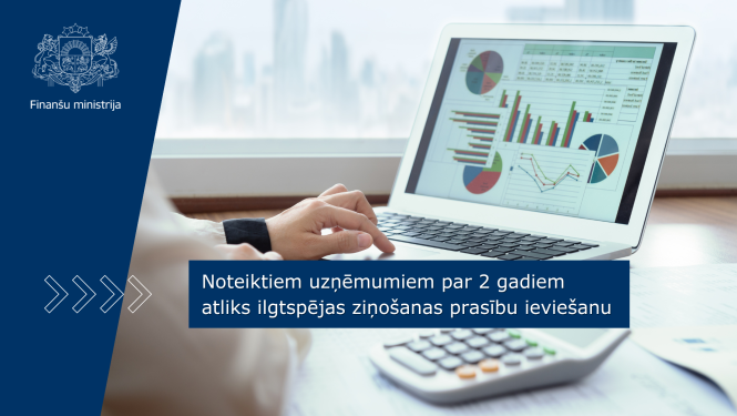 Attēlā uz galda redzams portatīvais dators, kura ekrānā redzami dažādi grafiki, vēl uz galda redzami dokumenti un kalkulators, kā arī cilvēka roka, kas strādā ar datoru