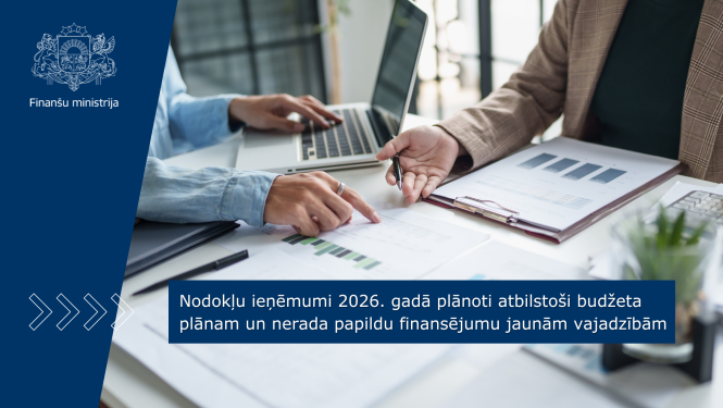 Pie darba gada sēž divi cilvēki un strādā ar dokumentiem un portatīvo datoru