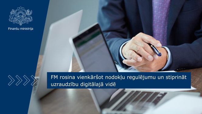 Vīrietis sēž pie galda, tur rokās pildspalvu un norāda uz uz galda esošajiem dokumentiem un portatīvo datoru