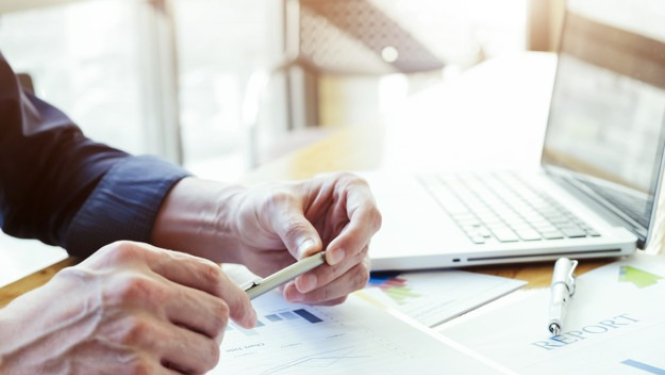 Rokas tur pildspalvu uz darba galda fona