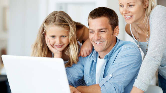 Ģimene - meita, tētis un mamma skatās datora ekrānā un smaida