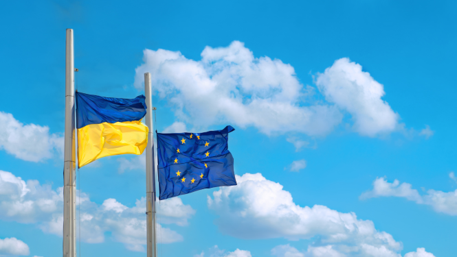 Ukrainas un ES karogi mastos uz zilu debesu fona