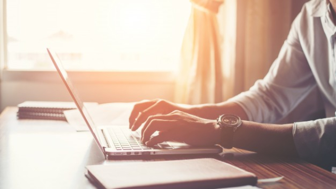 attēlā redzama sieviete, kura strādā ar datoru