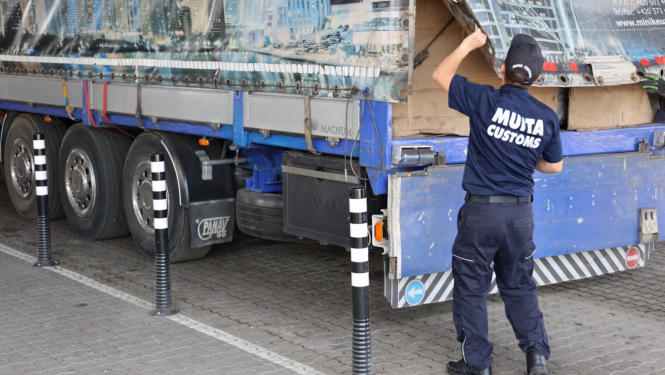 Muitas darbinieks veic pārbaudi fūres kravai