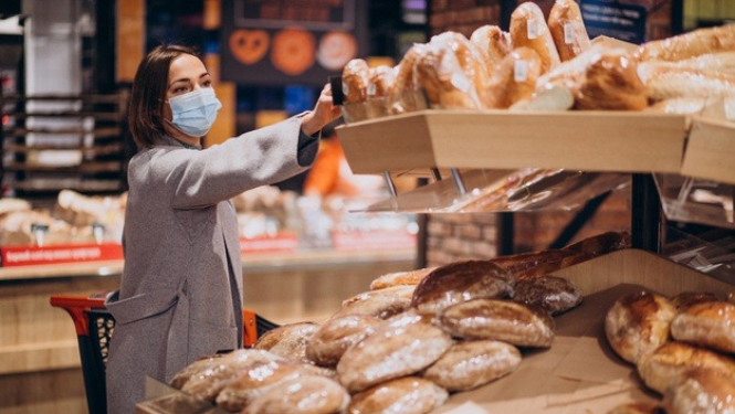 Sieviete sejas maskā iepērkas veikalā