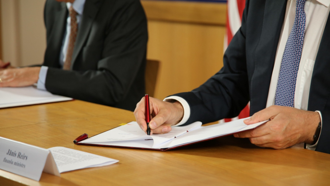 finanšu ministrs paraksta dokumentu
