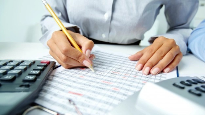 Sieviete pie galda raksta