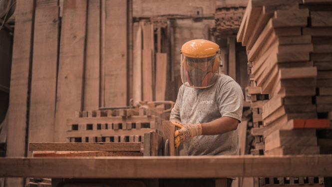 vīrietis apstrādā koku