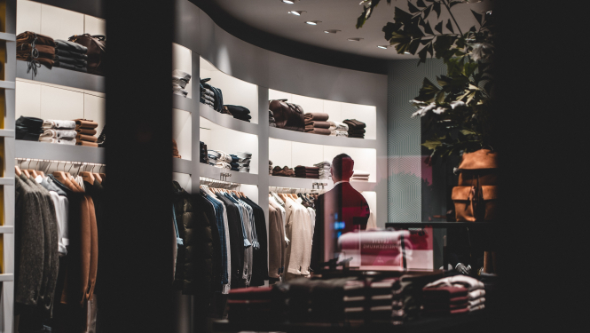 Skats veikalā caur skatlogu, vīrietis pēta apģērbu