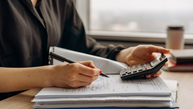 Sieviete veic aprēķinus ar kalkulatoru