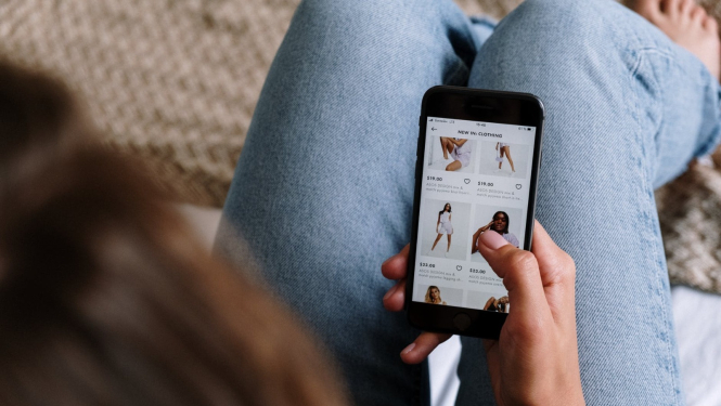 Sieviete iepērkas interneta veikalā, izmantojot mobilo telefonu