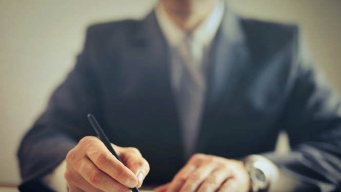 Vīrietis, kas paraksta dokumentu