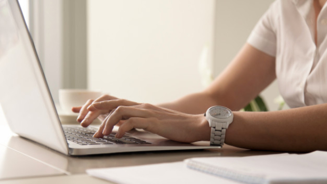 Sievietes rokas drukā tekstu uz datora tastatūras