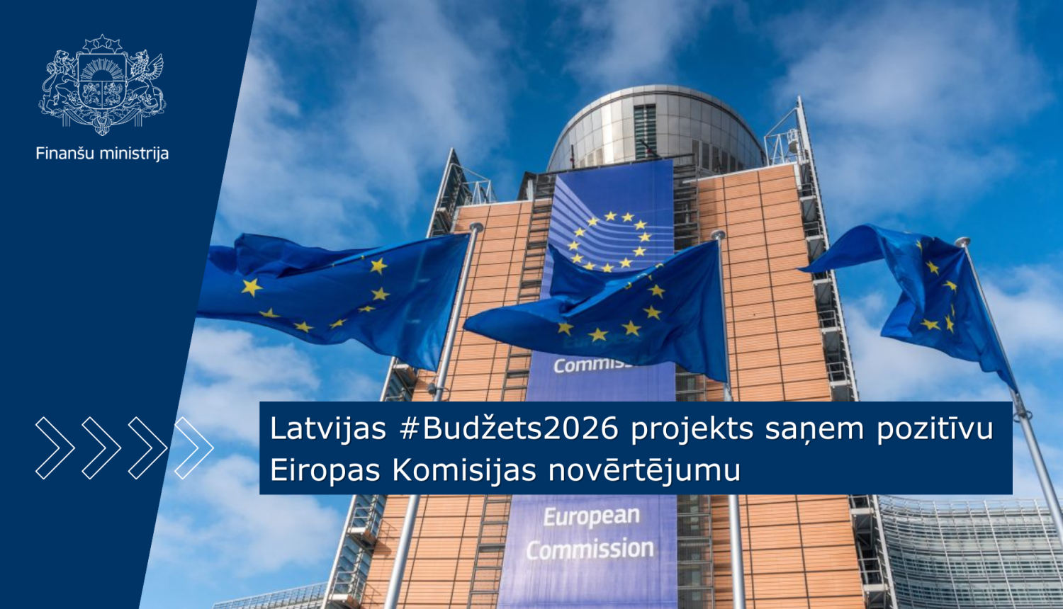 Attēlā redzama Eiropas komisijas ēka, kuras priekšplānā plīvo trīs ES karogi, uz attēla ir teksts