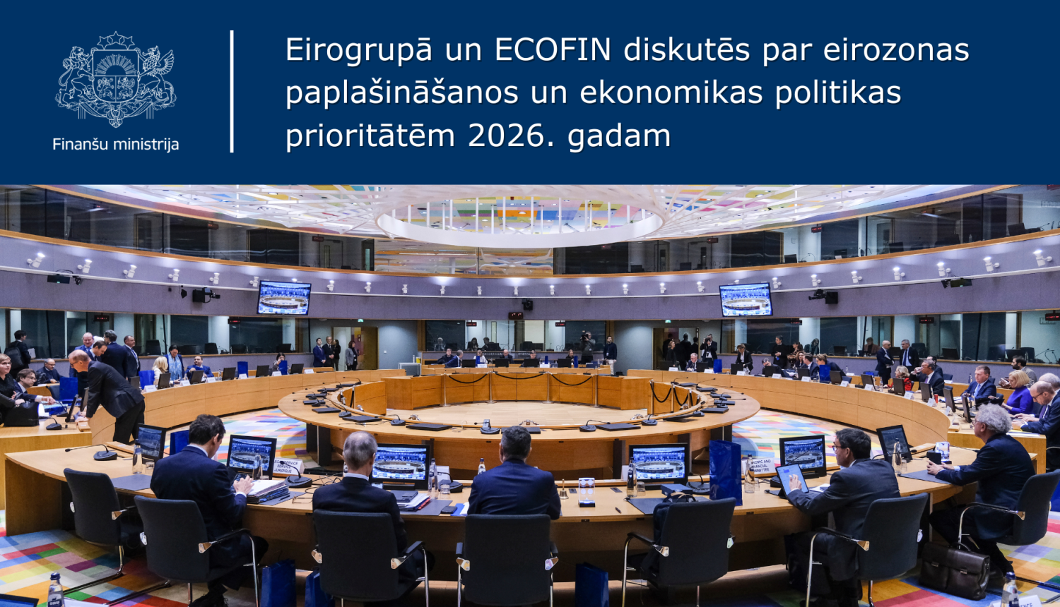 Plaša skata foto ar apaļu sanāksmju zāli, kur pie liela apļa galda sēž un strādā ES finanšu ministri Eirogrupas un ECOFIN sanāksmē, uz attēla ir teksts un ministrijas ģerbonis uz zila fona.
